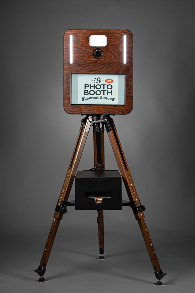 un photobooth bois sur pied en fonctionnement sur un fond gris